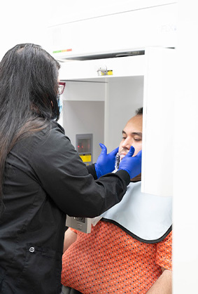 Dental team member taking dental scans of a patient in Dallas