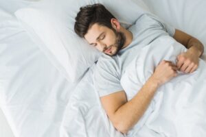 a man sleeping in a bed 